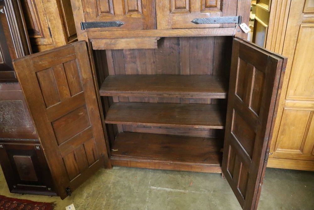 A French oak rustic-style panelled cupboard fitted upper and lower pairs of doors, width 122cm, depth 50cm, height 198cm